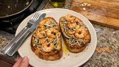 Tostas de gulas y gambas al ajillo: el aperitivo caliente que se hace en 10 minutos