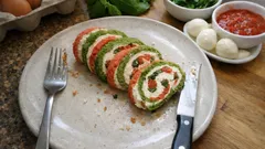 Rollo frío de queso crema con tomate y albahaca: el aperitivo que puedes dejar hecho